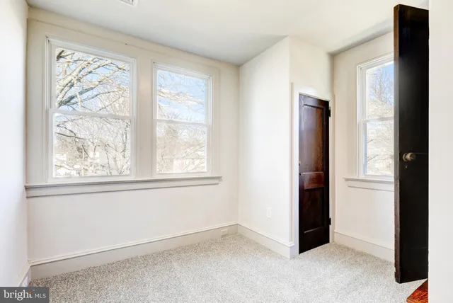 an empty room with windows and closet