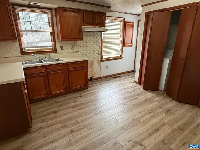 a view of kitchen with wooden floor and electronic appliances