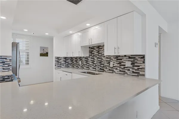 a kitchen with stainless steel appliances a refrigerator sink and microwave