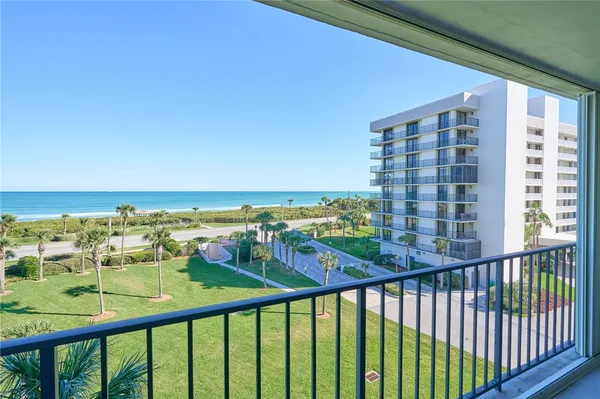 a view of a balcony with chair and floor to ceiling window