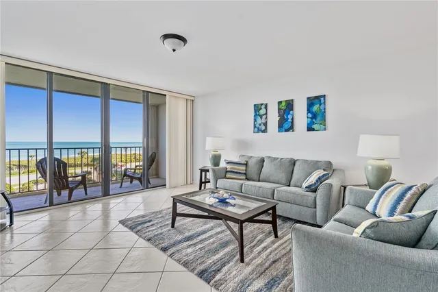 a living room with furniture a chandelier and a dining table