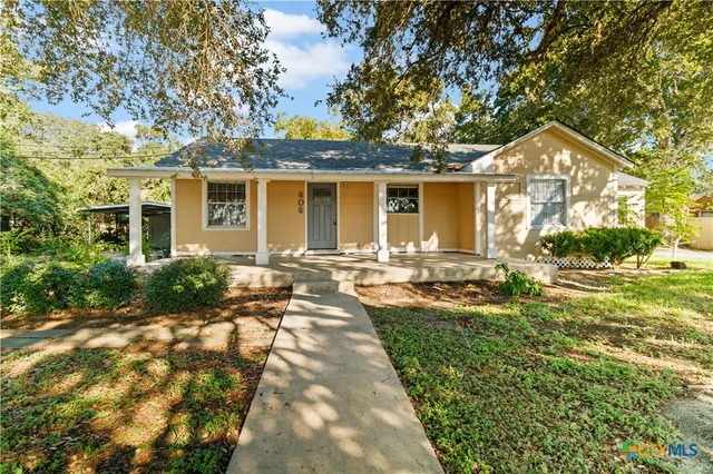 a front view of a house with yard patio and green space