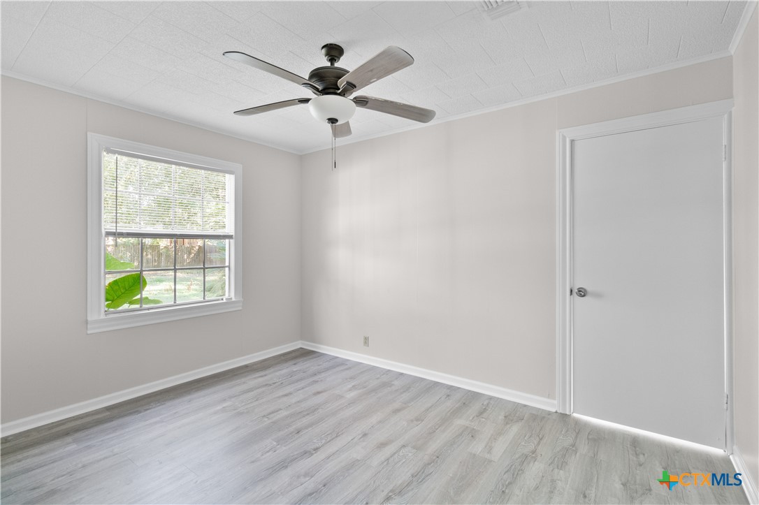 606 West Gayle Street Edna, TX 77957 - Photo 14 of 20 wooden floor in an empty room with a window