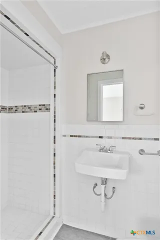 a bathroom with a sink a mirror and a shower