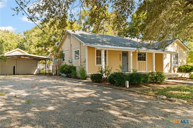 a front view of a house with a yard and potted plants