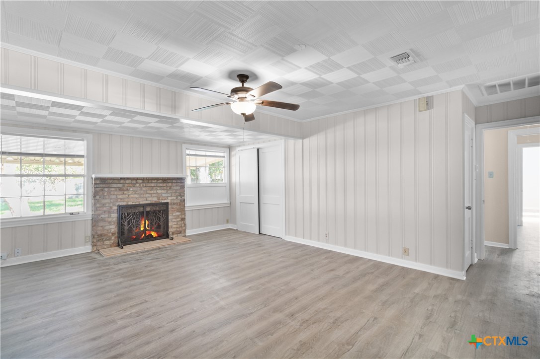 606 West Gayle Street Edna, TX 77957 - Photo 4 of 20 wooden floor fireplace and windows in an empty room