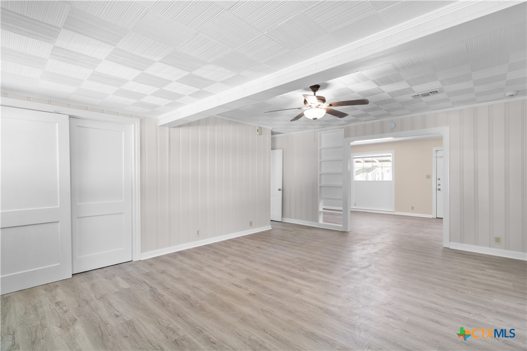 606 West Gayle Street Edna, TX 77957 - Photo 5 of 20 wooden floor in an empty room with a window