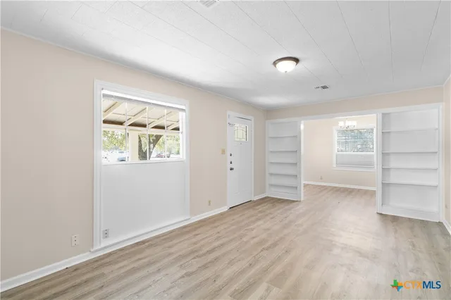 wooden floor in an empty room with a window