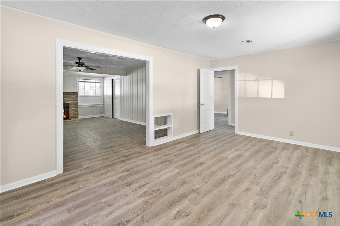 606 West Gayle Street Edna, TX 77957 - Photo 7 of 20 wooden floor in an empty room with a window