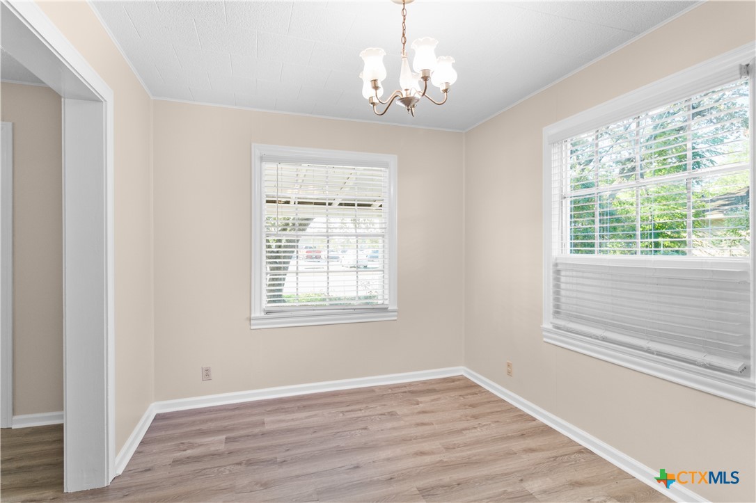 606 West Gayle Street Edna, TX 77957 - Photo 8 of 20 a view of an empty room with wooden floor and a window