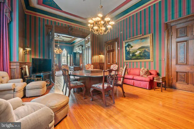 a view of a dining room with furniture a chandelier and wooden floor