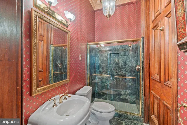 a bathroom with a sink a toilet a mirror and shower