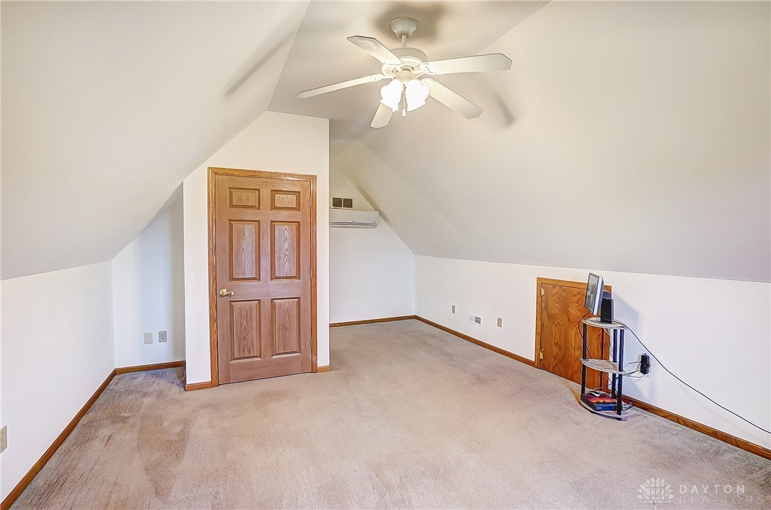 1540 Jasper Road Xenia, OH 45385 - Photo 43 of 91 An inviting attic room features sloped ceilings and soft carpeting, creating a cozy and adaptable space.