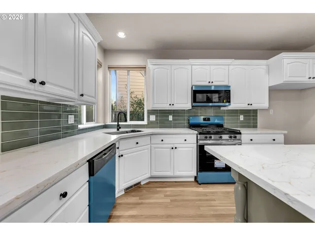 a kitchen with kitchen island granite countertop a sink cabinets and stainless steel appliances