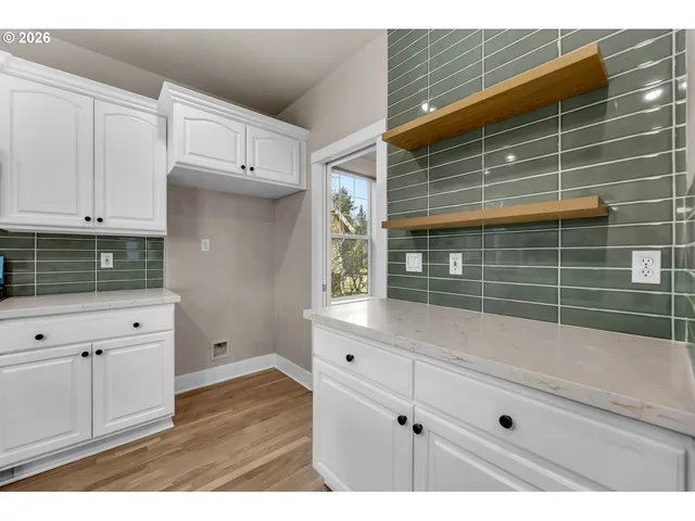 a kitchen with a wooden floor and white cabinets