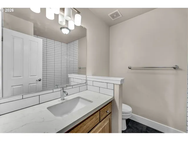 a bathroom with a sink a toilet and mirror