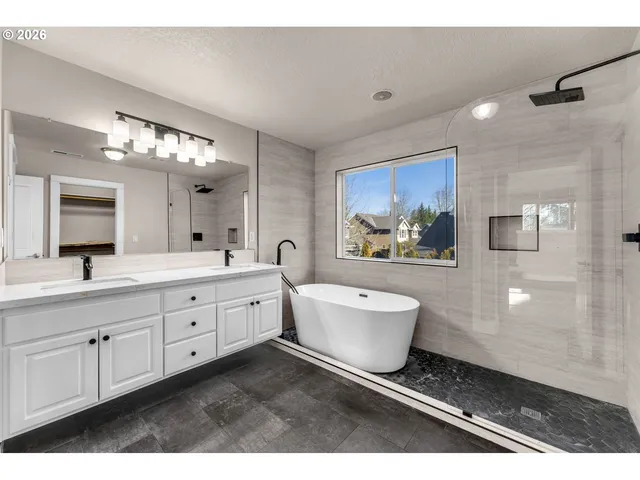 a spacious bathroom with a double vanity sink a mirror and a bathtub
