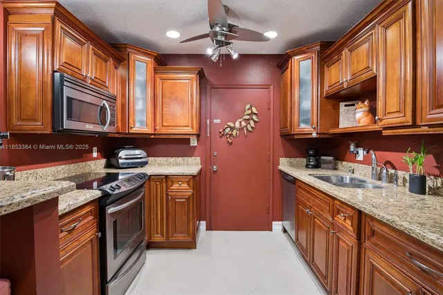 a kitchen with stainless steel appliances granite countertop a sink stove and cabinets