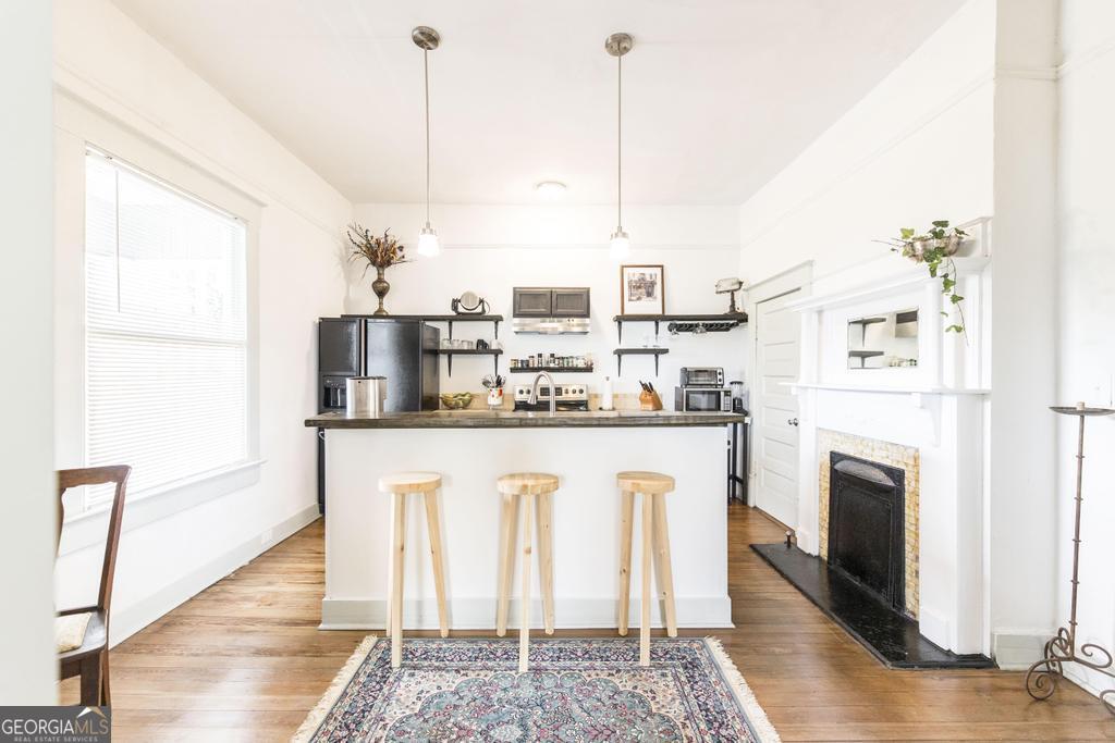 1475 3rd Street Macon, GA 31201 - Photo 14 of 37 a kitchen with stainless steel appliances granite countertop a refrigerator a oven and white cabinets with wooden floors