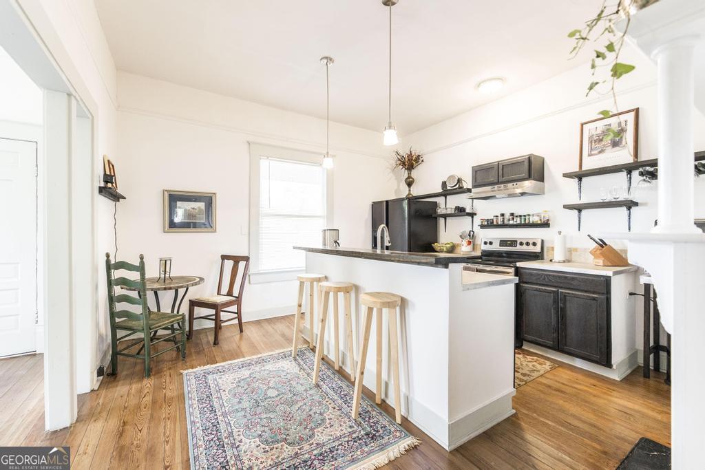 1475 3rd Street Macon, GA 31201 - Photo 15 of 37 a kitchen with stainless steel appliances granite countertop a refrigerator a stove top oven a sink dishwasher and white cabinets with wooden floor