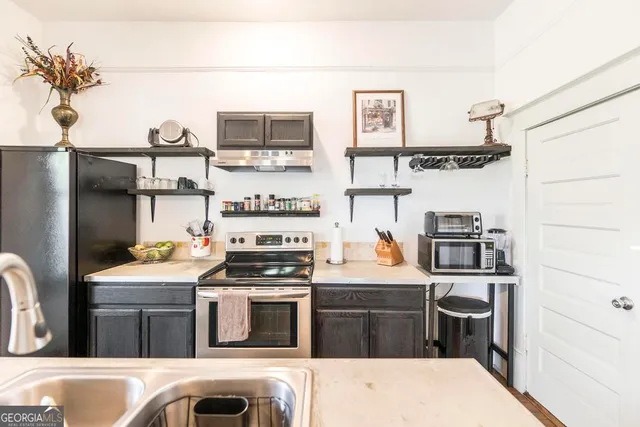 a kitchen with stainless steel appliances kitchen island granite countertop a refrigerator stove and sink