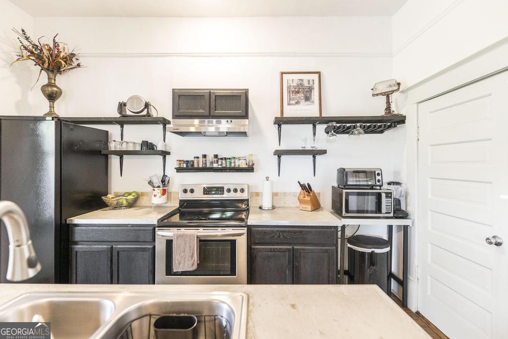 1475 3rd Street Macon, GA 31201 - Photo 16 of 37 a kitchen with stainless steel appliances kitchen island granite countertop a refrigerator stove and sink