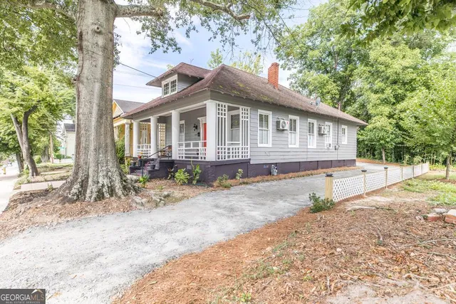 a front view of a house with a yard and potted plants