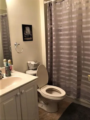 a bathroom with a toilet a sink and mirror