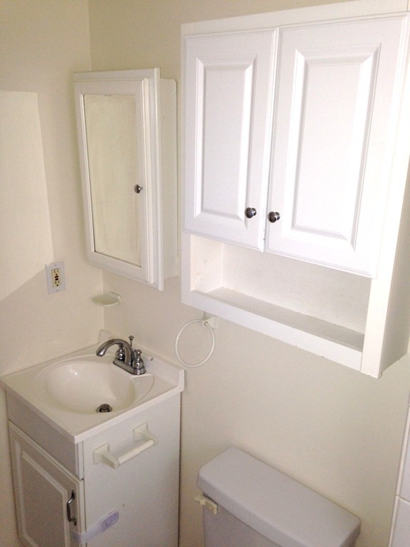 5 Malta Street Hull, MA 02045 - Photo 6 of 16 a bathroom with a sink a toilet and a mirror