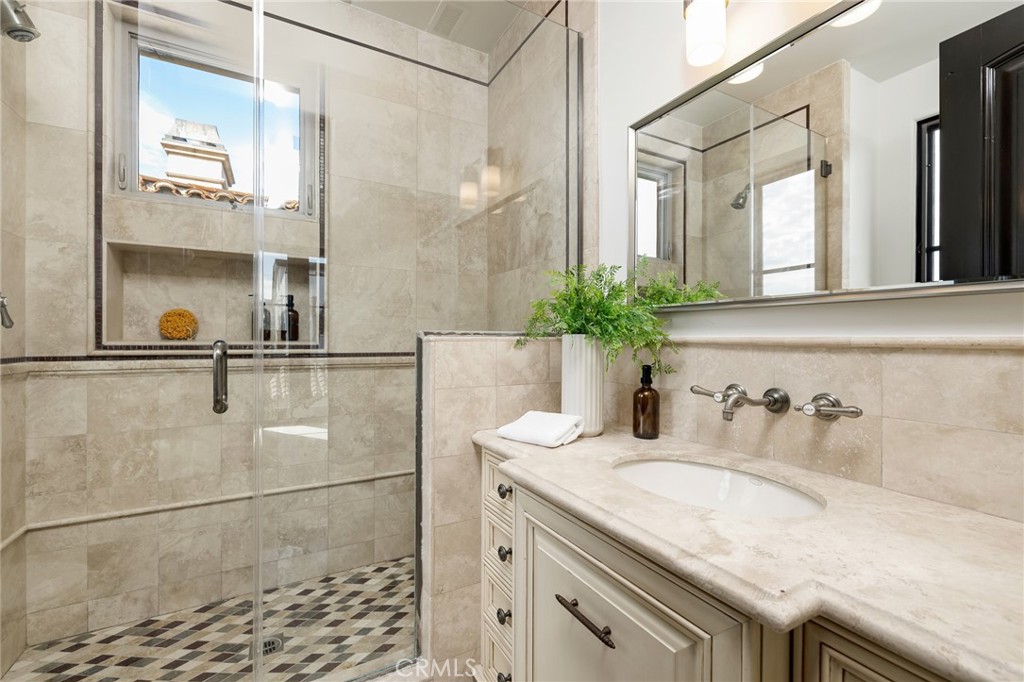 624 14th Street Manhattan Beach, CA 90266 - Photo 41 of 75 a bathroom with a granite countertop sink a mirror and a shower