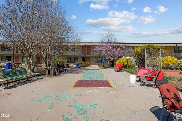 a view of a patio with table and chairs a barbeque with potted plants and floor to ceiling window