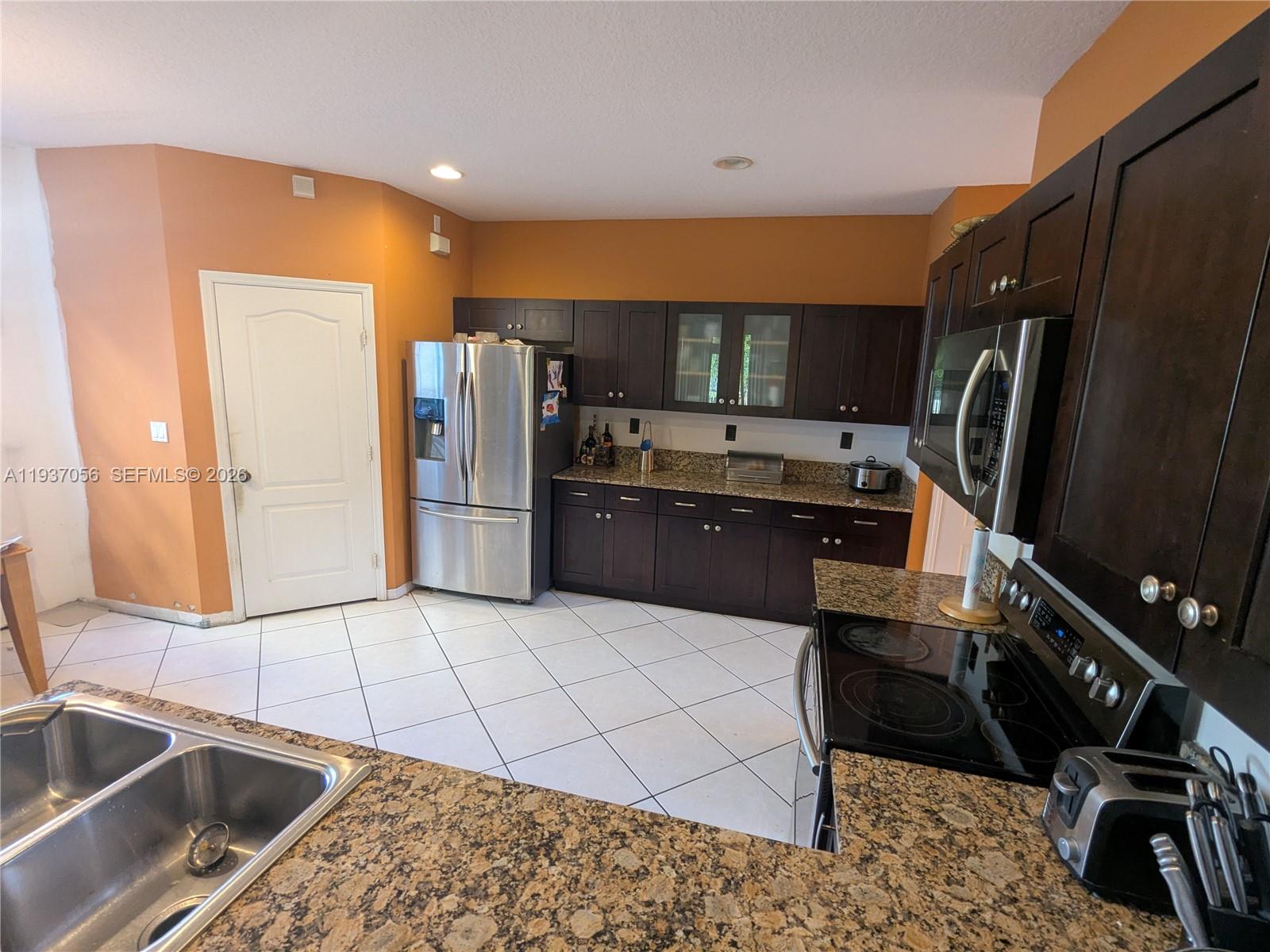 12641 Southwest 28th Street Miramar, FL 33027 - Photo 13 of 61 a kitchen with granite countertop a sink appliances and cabinets