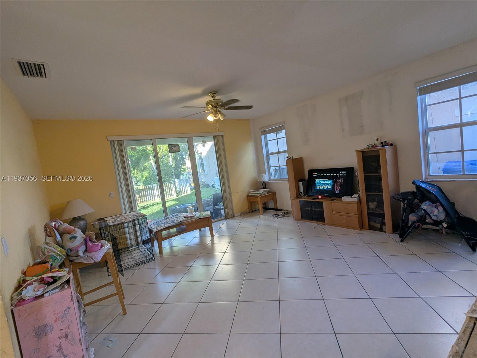 12641 Southwest 28th Street Miramar, FL 33027 - Photo 15 of 61 a living room with furniture a flat screen tv and a large window