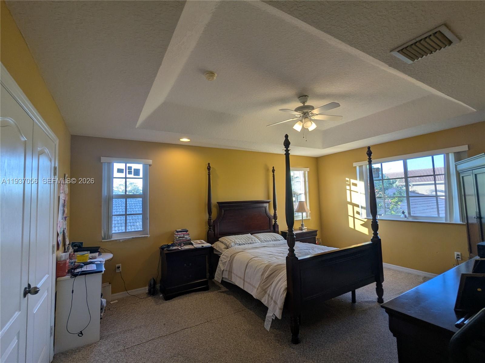12641 Southwest 28th Street Miramar, FL 33027 - Photo 16 of 52 Spacious primary bedroom featuring a dramatic tray ceiling and plenty of natural light