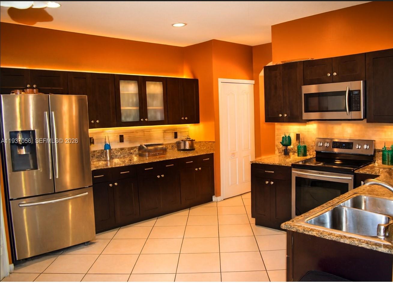 12641 Southwest 28th Street Miramar, FL 33027 - Photo 2 of 61 a kitchen with stainless steel appliances granite countertop a refrigerator and a sink