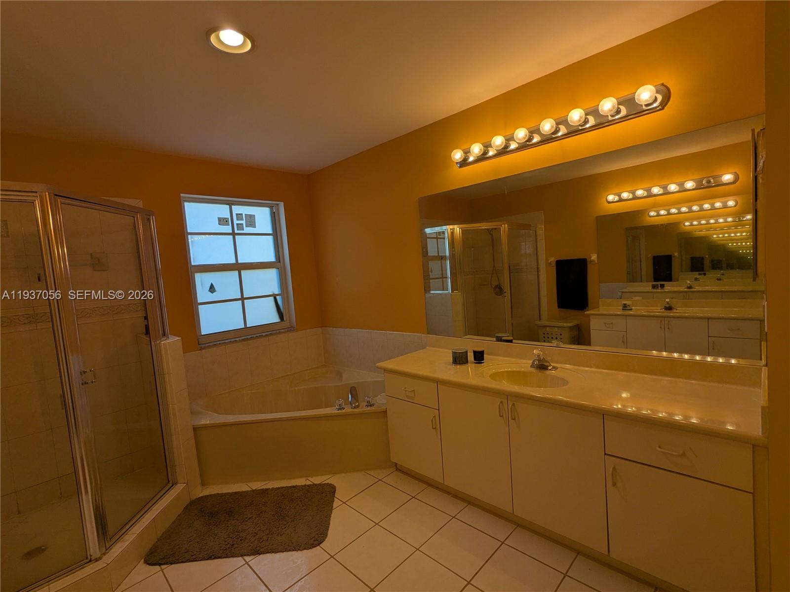 12641 Southwest 28th Street Miramar, FL 33027 - Photo 23 of 61 a bathroom with a sink a large mirror and a shower