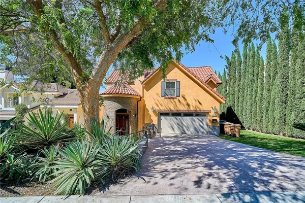 a view of a house with a tree next to a yard
