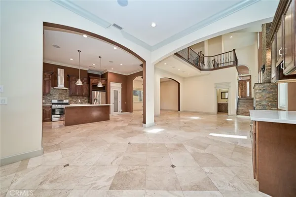 a large kitchen with kitchen island a sink a stove a counter space and cabinets