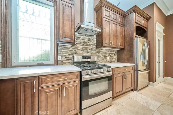 a large kitchen with stainless steel appliances kitchen island granite countertop a refrigerator a oven a sink and a counter top space