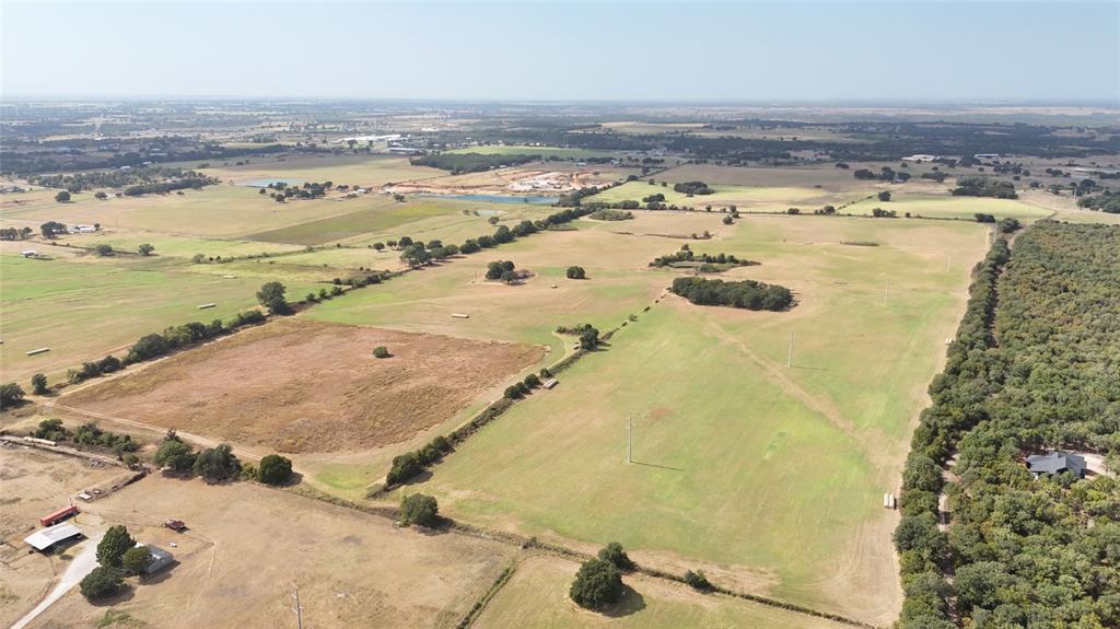 2101 Billings Road Tolar, TX 76476 - Photo 6 of 23 Expansive acreage featuring open fields, clusters of mature trees, and a residential structure nestled within a densely wooded area