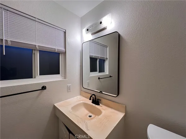 a bathroom with a sink toilet and mirror