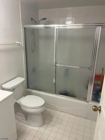 a white toilet sitting next to a shower