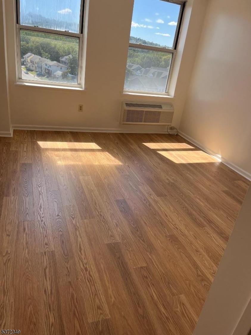 300 Main Street, Unit 901 Little Falls, NJ 07424 - Photo 8 of 15 an empty room with wooden floor and windows