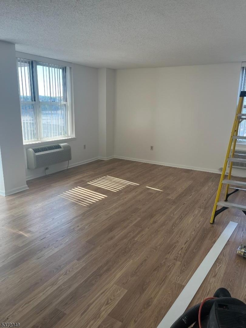 300 Main Street, Unit 901 Little Falls, NJ 07424 - Photo 9 of 15 an empty room with wooden floor and windows