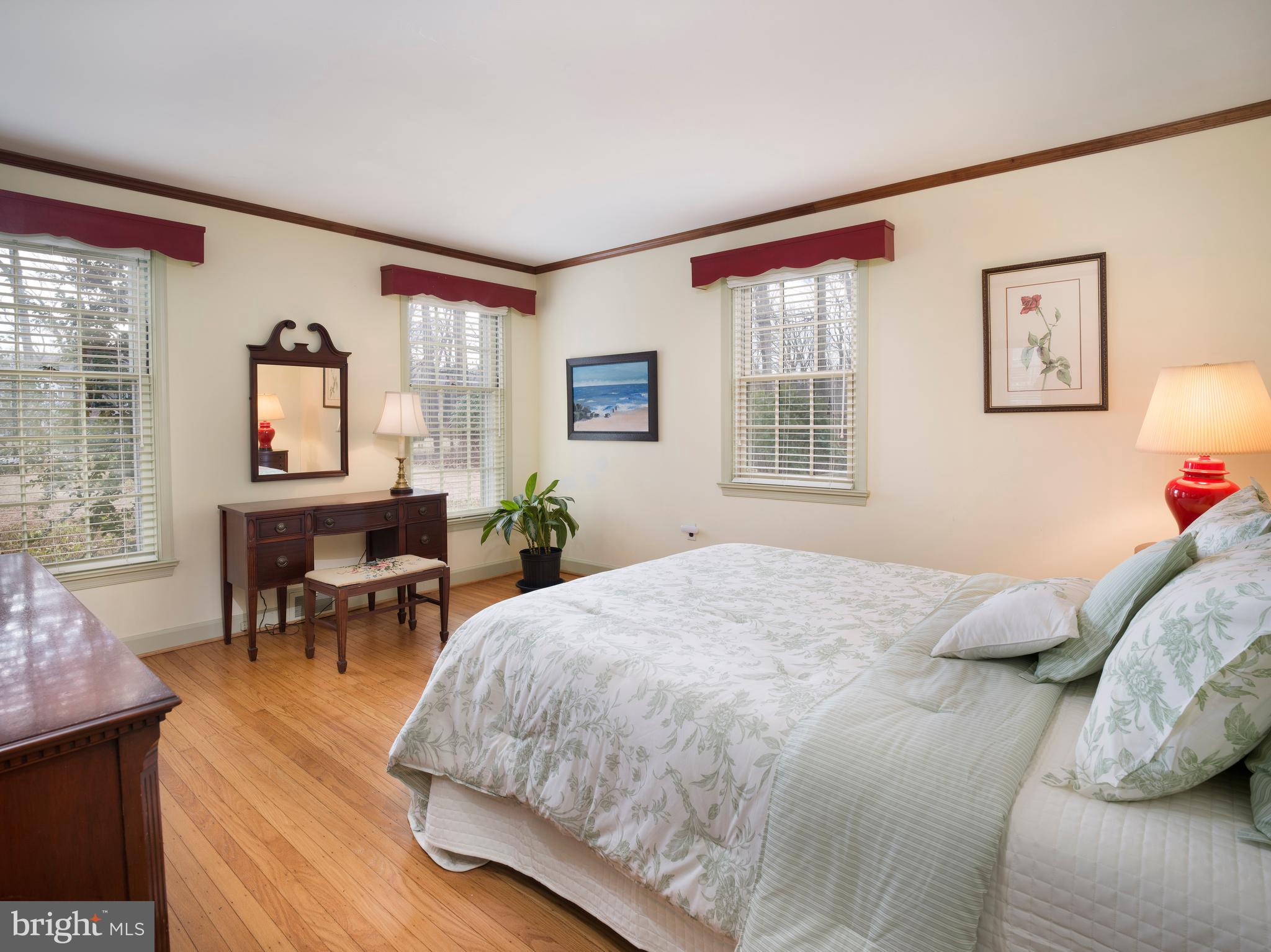 34 Ridgewood Road Wayne, PA 19087 - Photo 13 of 28 a bedroom with a bed a table and chair with wooden floor