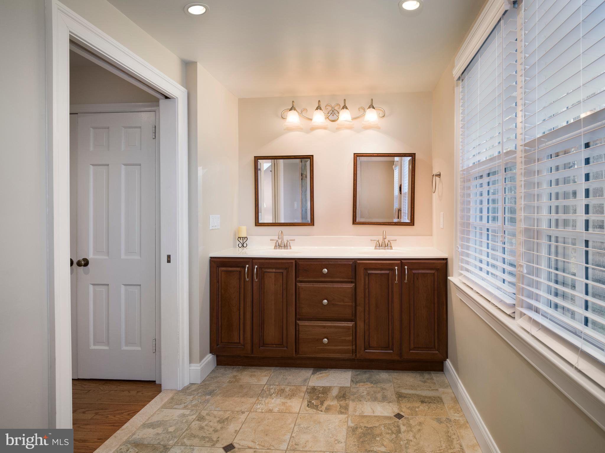 34 Ridgewood Road Wayne, PA 19087 - Photo 19 of 28 a bathroom with a granite countertop sink a mirror and a vanity