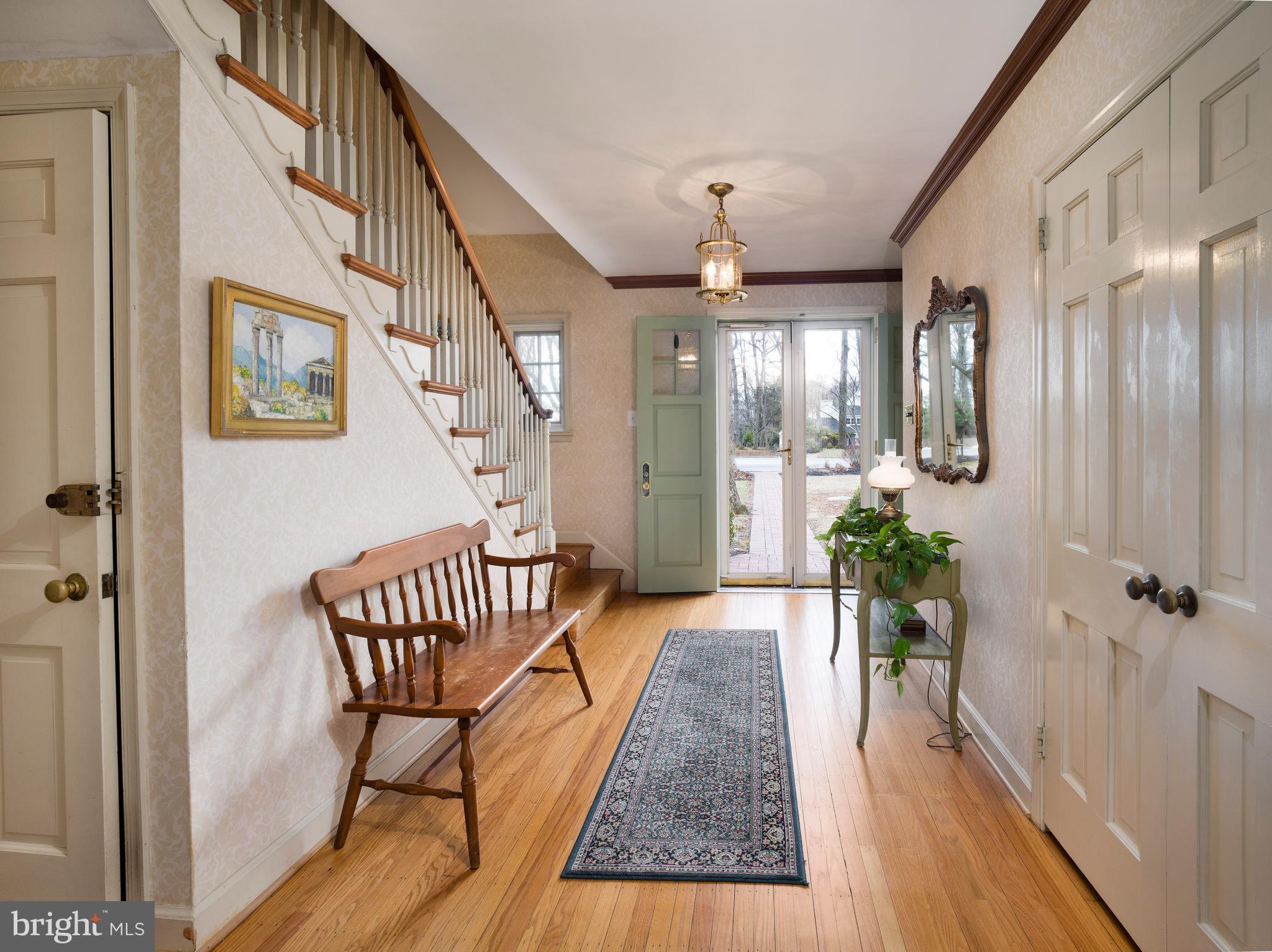 34 Ridgewood Road Wayne, PA 19087 - Photo 2 of 28 a view of a hallway to a livingroom with wooden floor and furniture