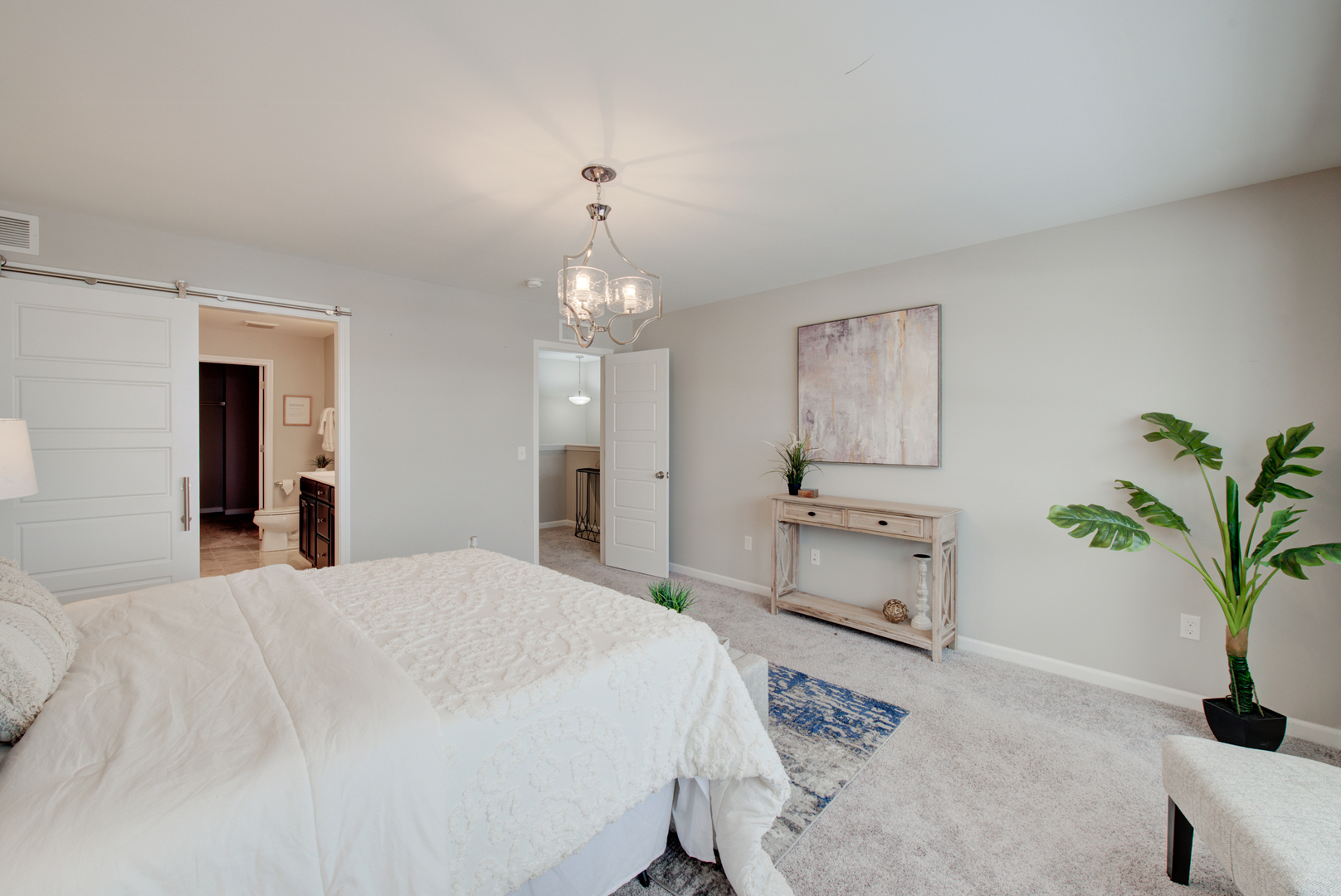980 Station Boulevard Aurora, IL 60504 - Photo 12 of 27 a spacious bedroom with a bed and a chandelier