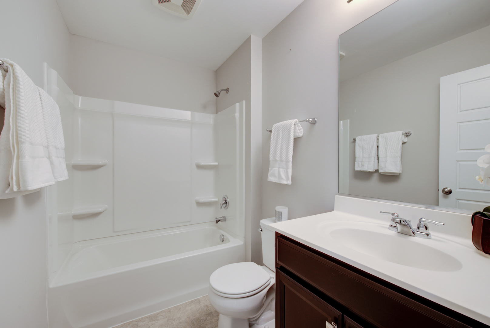 980 Station Boulevard Aurora, IL 60504 - Photo 19 of 27 a bathroom with a sink a toilet and a large mirror