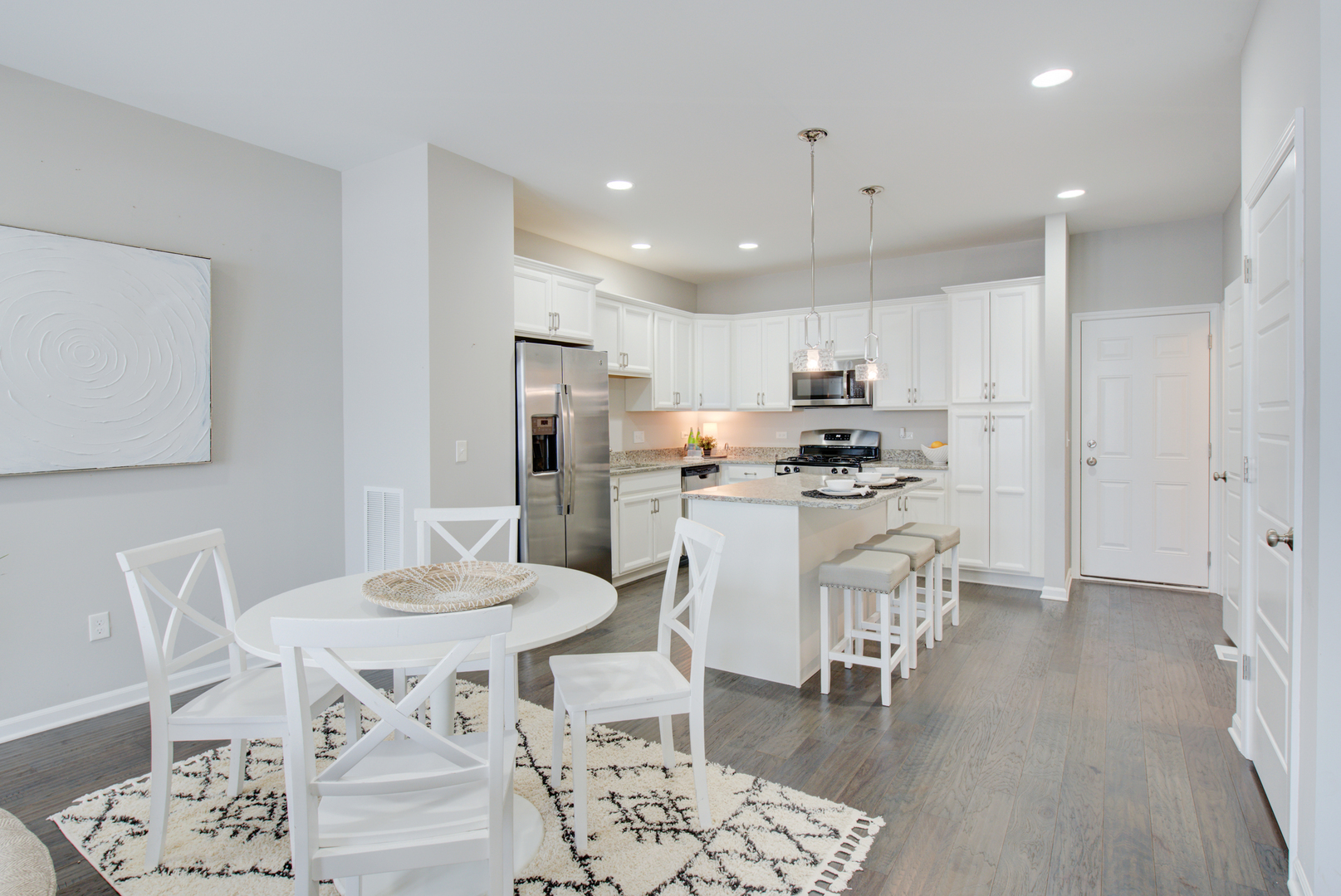 980 Station Boulevard Aurora, IL 60504 - Photo 6 of 27 a kitchen with a dining table chairs refrigerator and microwave